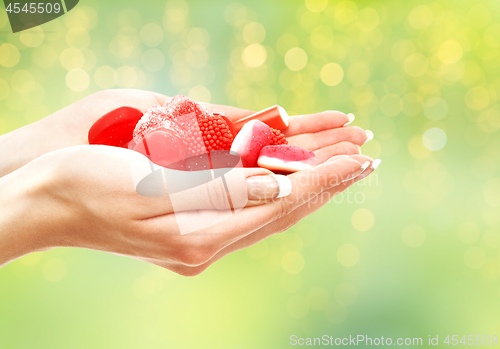 Image of close up of hands holding red jelly candies