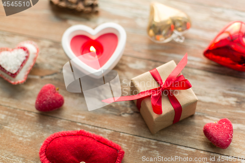 Image of christmas gift, heart shaped decorations, candle