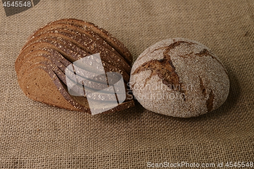 Image of slices and loaf of rye bread on burlap