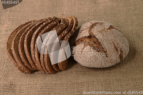 Image of slices and loaf of rye bread on burlap