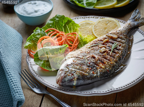 Image of grilled fish on wooden kitchen table