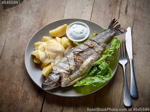 Image of grilled fish on wooden kitchen table