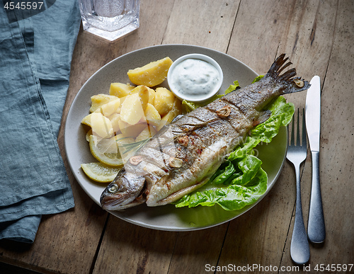 Image of grilled fish on wooden kitchen table