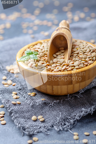 Image of Organic brown lentils and wooden scoop in a bowl.