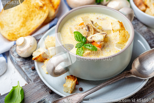 Image of Saucepan with chicken cream soup with mushrooms.