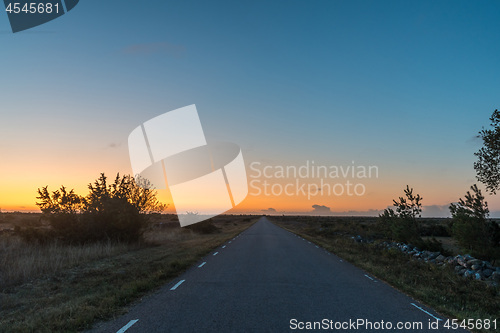 Image of Sunrise at a country road in a plane barren landscape