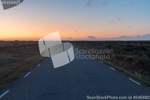 Image of Morning with colored sky by a road in a plain barren grassland