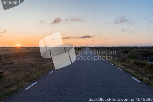 Image of Straight road by sunrise in a great barren landscape