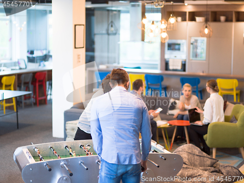 Image of Office People Enjoying Table Soccer Game