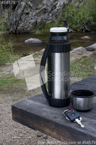 Image of stop and rest when driving - car key, thermos bottle on picnic t