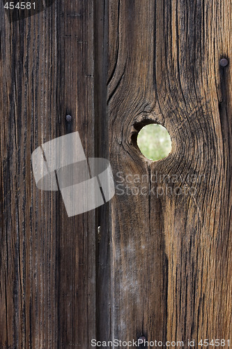 Image of peephole - weathered wood background with a knothole
