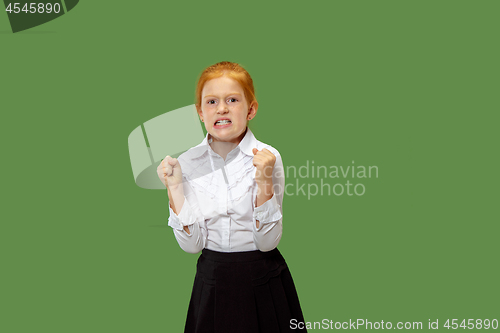 Image of Portrait of angry teen girl on a green studio background