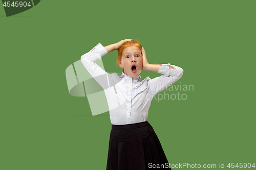 Image of Beautiful teen girl looking suprised isolated on green