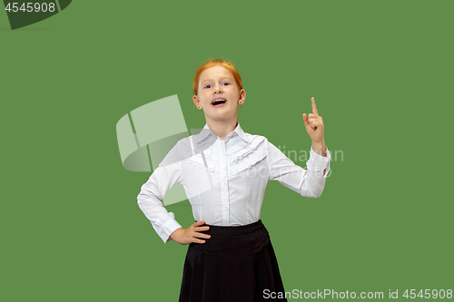 Image of The happy teen girl standing and smiling against green background.