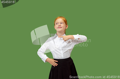 Image of The happy teen girl standing and smiling against green background.