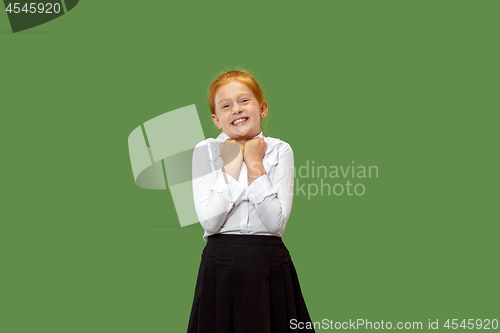 Image of The happy teen girl standing and smiling against green background.