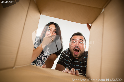 Image of The couple unpacking and opening carton box and looking inside