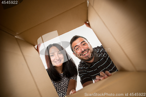 Image of The couple unpacking and opening carton box and looking inside