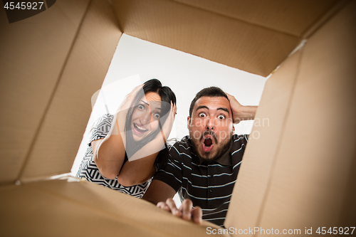 Image of The couple unpacking and opening carton box and looking inside