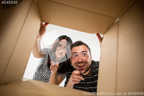 Image of The couple unpacking and opening carton box and looking inside