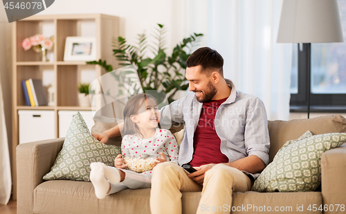 Image of happy father and daughter watching tv at home