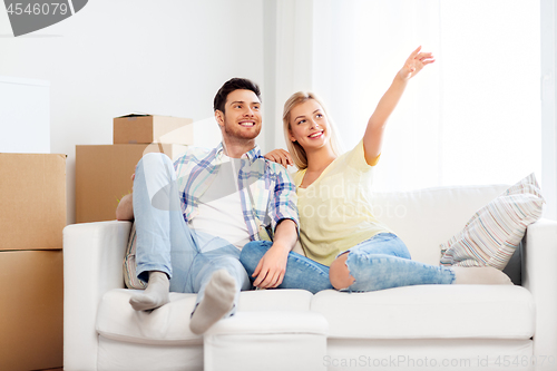 Image of happy couple with cardboard boxes at new home