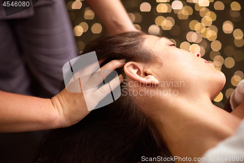 Image of woman having head massage at spa