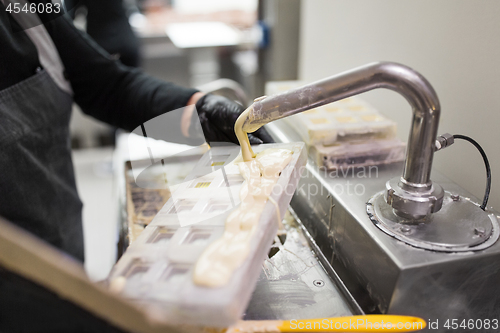 Image of confectioner makes chocolate candies at sweet-shop