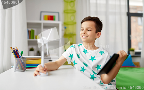 Image of boy with tablet and model of wind turbine at home