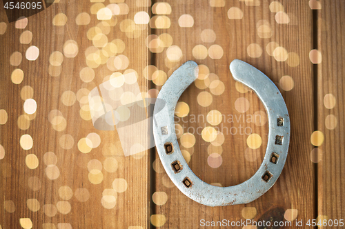 Image of old horseshoe on wooden background