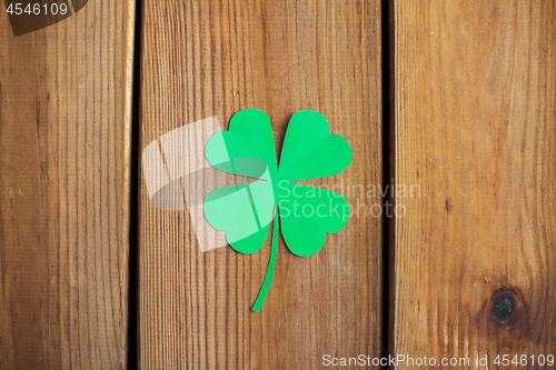 Image of green paper shamrock on wooden background