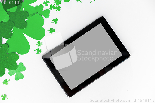 Image of tablet pc and st patricks day decorations on white