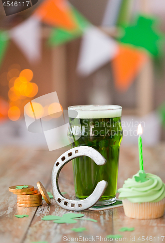 Image of glass of beer, cupcake, horseshoe and gold coins