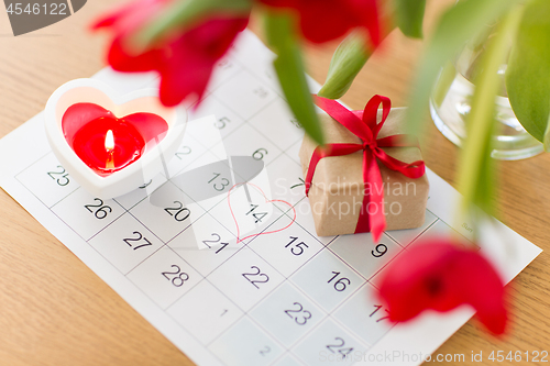 Image of gift box, calendar sheet and flowers on table