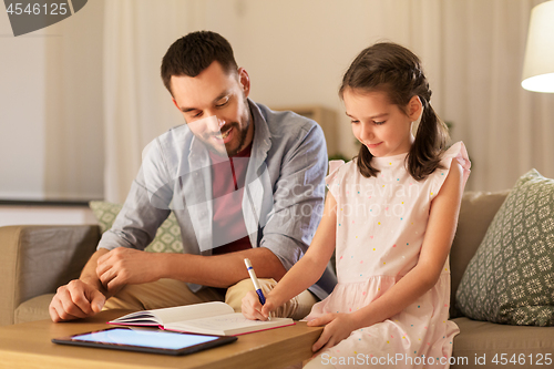 Image of father and daughter doing homework together