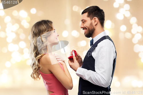 Image of man giving woman engagement ring on valentines day