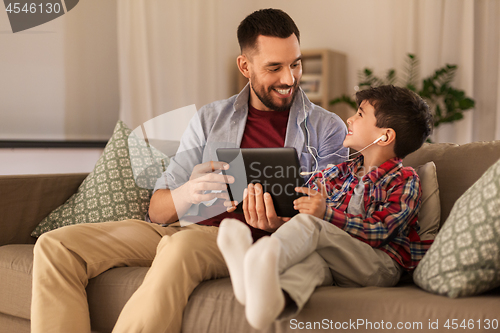 Image of father and son listening to music on tablet pc