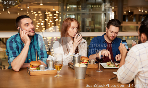 Image of friends dining and drinking wine at restaurant