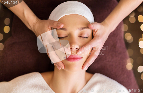 Image of woman having face and head massage at spa