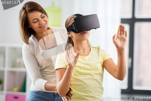 Image of mother and daughter in vr glasses playing at home