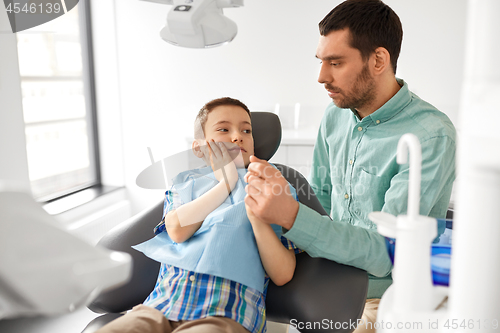 Image of father supporting son at dental clinic