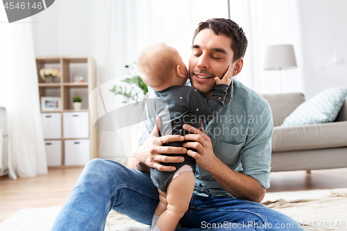 Image of happy father with little baby daughter at home
