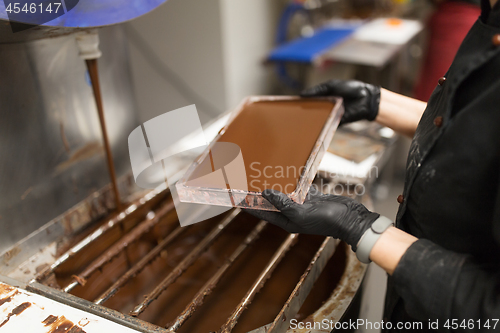 Image of confectioner makes chocolate candies at sweet-shop