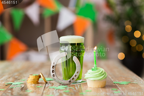 Image of glass of beer, cupcake, horseshoe and gold coins