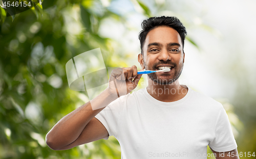 Image of indian man with toothbrush cleaning teeth