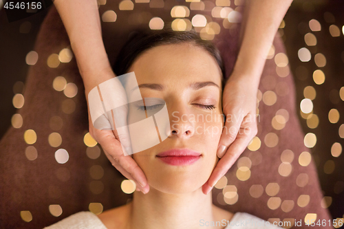 Image of woman having face and head massage at spa