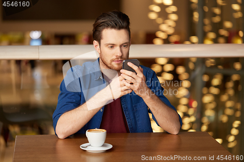 Image of man with coffee and smartphone at restaurant