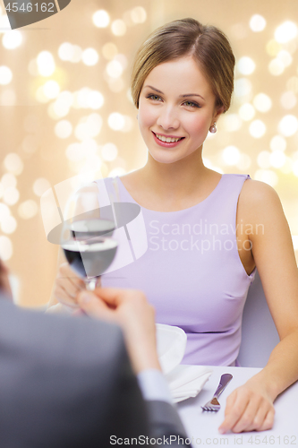 Image of woman drinking wine with her man at restaurant