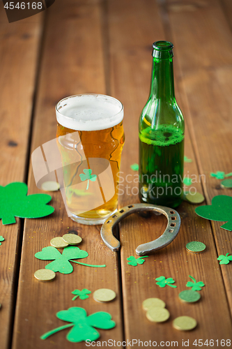 Image of glass of beer, bottle, horseshoe and gold coins