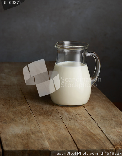 Image of milk jug on wooden table